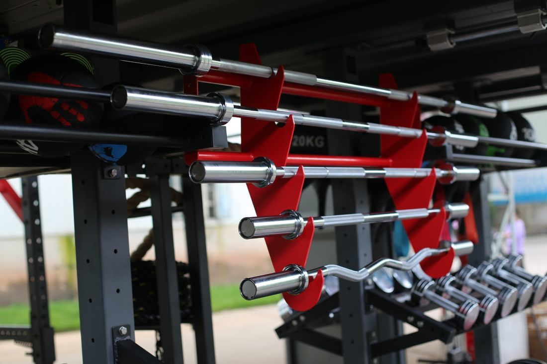 Outdoor Fitness: Weightlifting bars and dumbbells on a rack. Gym equipment for strength training and outdoor fitness workouts.